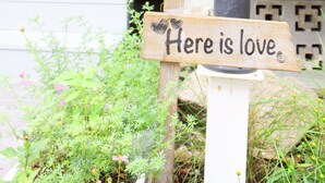 A wooden sign with the text 'Here is love' mounted on a white post. - Homeku Guesthouse Room 3 Cozy Stay Close to Suvarnabhumi Airport (Lat Krabang)