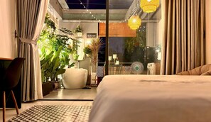 Un dormitorio moderno con cama, una silla y un ventanal grande.