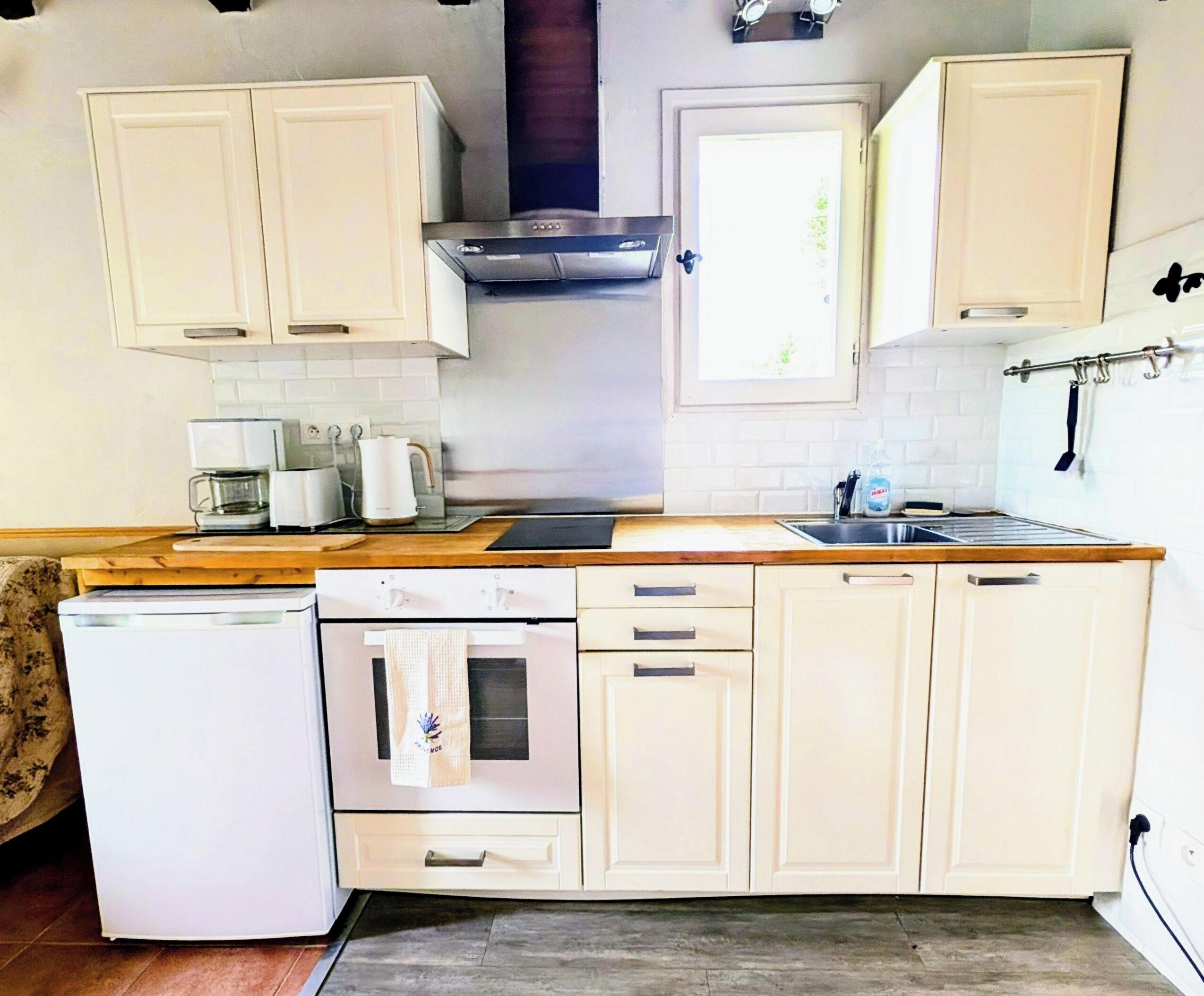 A kitchen with white cabinets, a stove, a dishwasher, and a refrigerator.