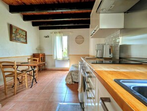 A kitchen with wooden cabinets, a sink, and a window with curtains.