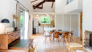Une cuisine spacieuse avec un coin repas, des meubles en bois et une cheminée.