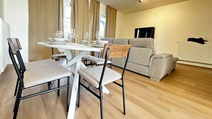 Una sala de estar moderna con comedor, sofá y radiador.