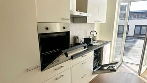 Una cocina moderna con horno integrado, electrodomésticos de acero inoxidable y lavavajillas.