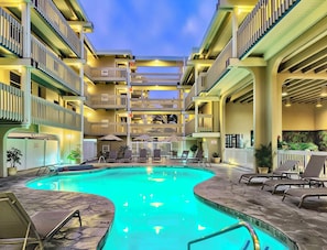 Ein mehrstöckiges Hotel mit Pool, Außenbereich und Balkonen.