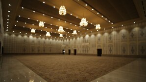 A large, well-lit hall with a patterned carpet, multiple chandeliers, and a high ceiling. - Anant Mahal Jaipur (Jaipur)