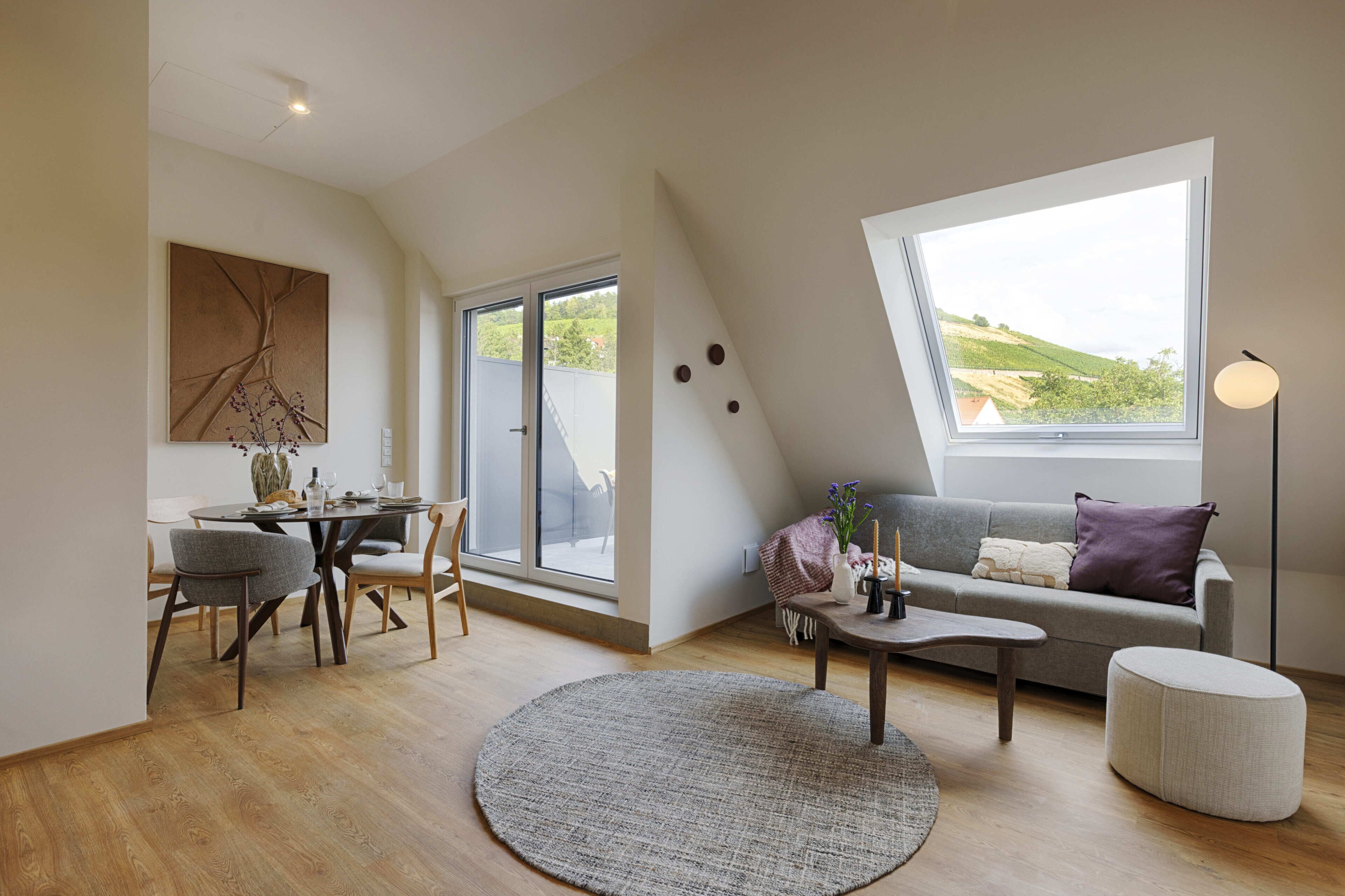 Un salon moderne comprenant un coin repas, un canapé, une table basse et une grande fenêtre offrant une belle vue.
