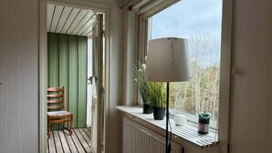 Ein Zimmer mit Fenster, Heizkörper, Stuhl und Blumentopf.