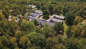 Ilmakuva lomakeskuksesta, jossa on useita rakennuksia, ja jonka ympärillä on tiheää metsää ja järviä.