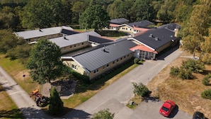 Asuinalue, jossa on useita taloja, asfaltoitu ajotie ja punainen auto, joka on pysäköity kadun varteen.