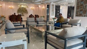A hotel lobby with seating arrangements, a reception desk, and decorative wall art. - Hotel Tuli Grand Imperial (Nagpur)
