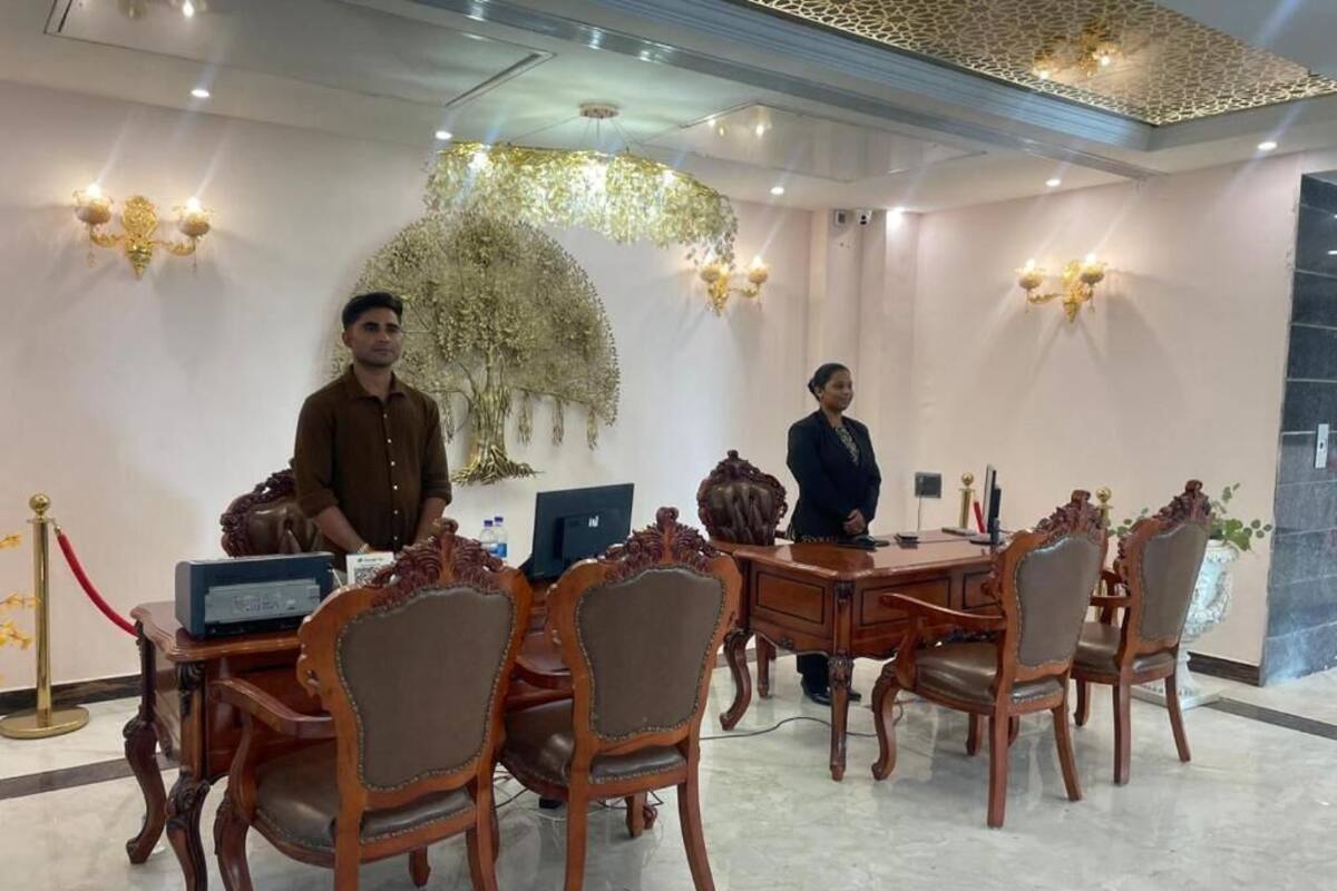 Un salón de conferencias con muebles de madera ornamentados, un candelabro y un tapiz decorativo.