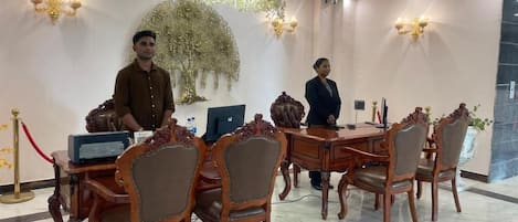 Un salón de conferencias con muebles de madera ornamentados, un candelabro y un tapiz decorativo.