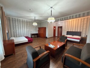A hotel room with a bed, desk, two chairs, a coffee table, and a chandelier. - Atlas Hotel Ulaanbaatar (Ulaanbaatar)