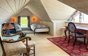 A cozy attic bedroom with two beds, a desk, and a chair. - Beautiful home in Thisted with house sea view (Thisted)
