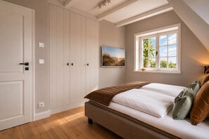 Ein Schlafzimmer mit Bett, Fenster mit Blick und Kleiderschrank.