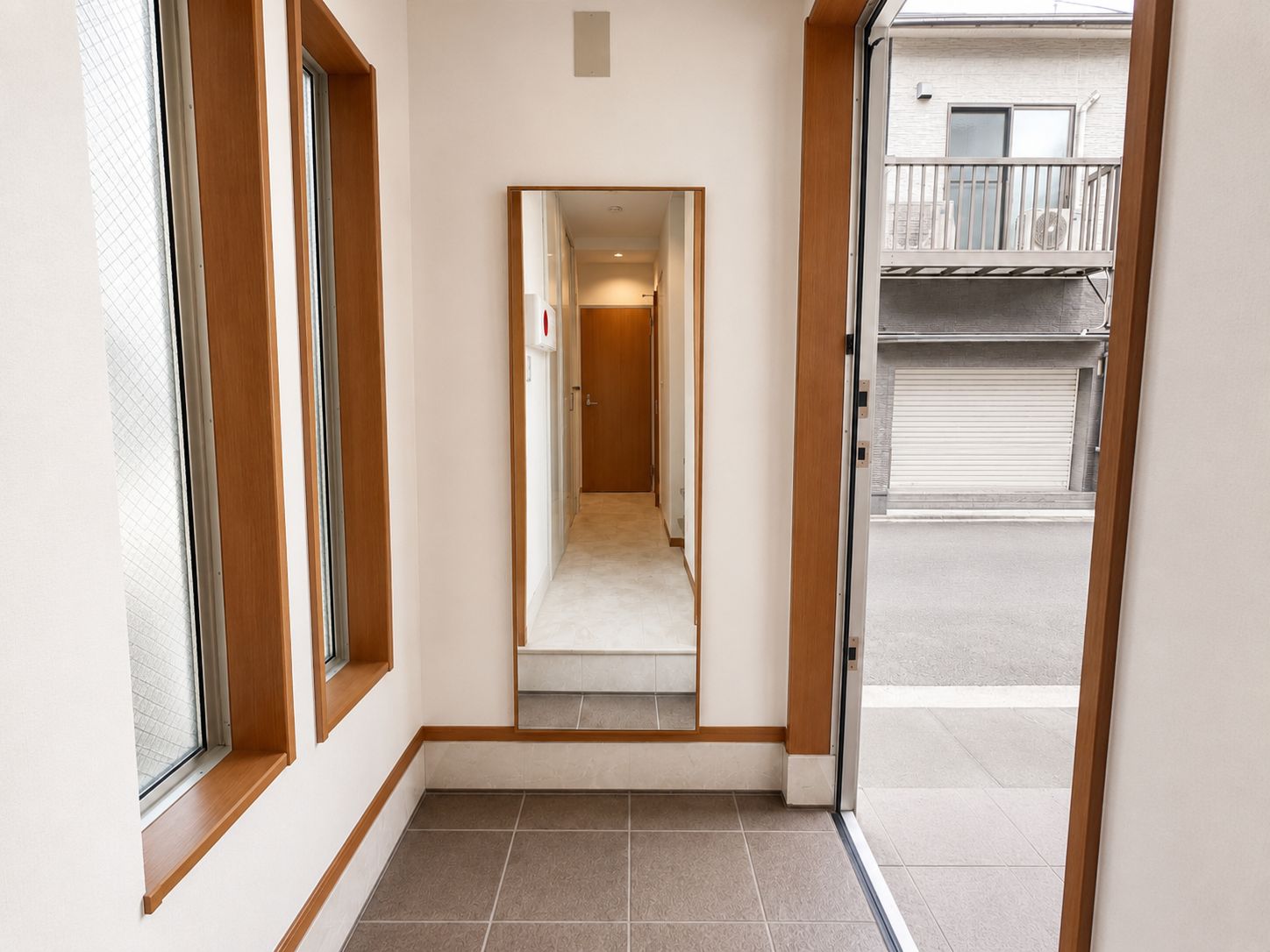 A narrow hallway with a door leading to a balcony.