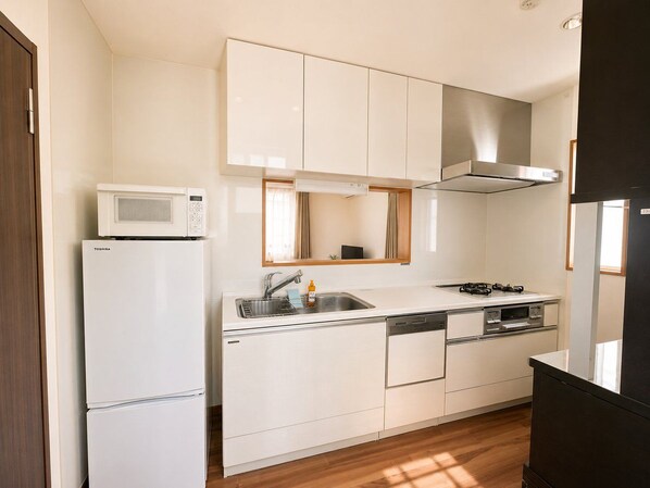 A compact kitchen with a microwave, sink, stove, and dishwasher.