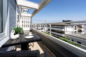Ein Balkon mit Tisch, Stühlen und einer Schwaneinrichtung.