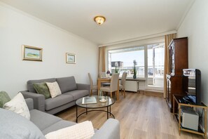 Ein modernes Wohnzimmer mit Sofa, Couchtisch und Essbereich.