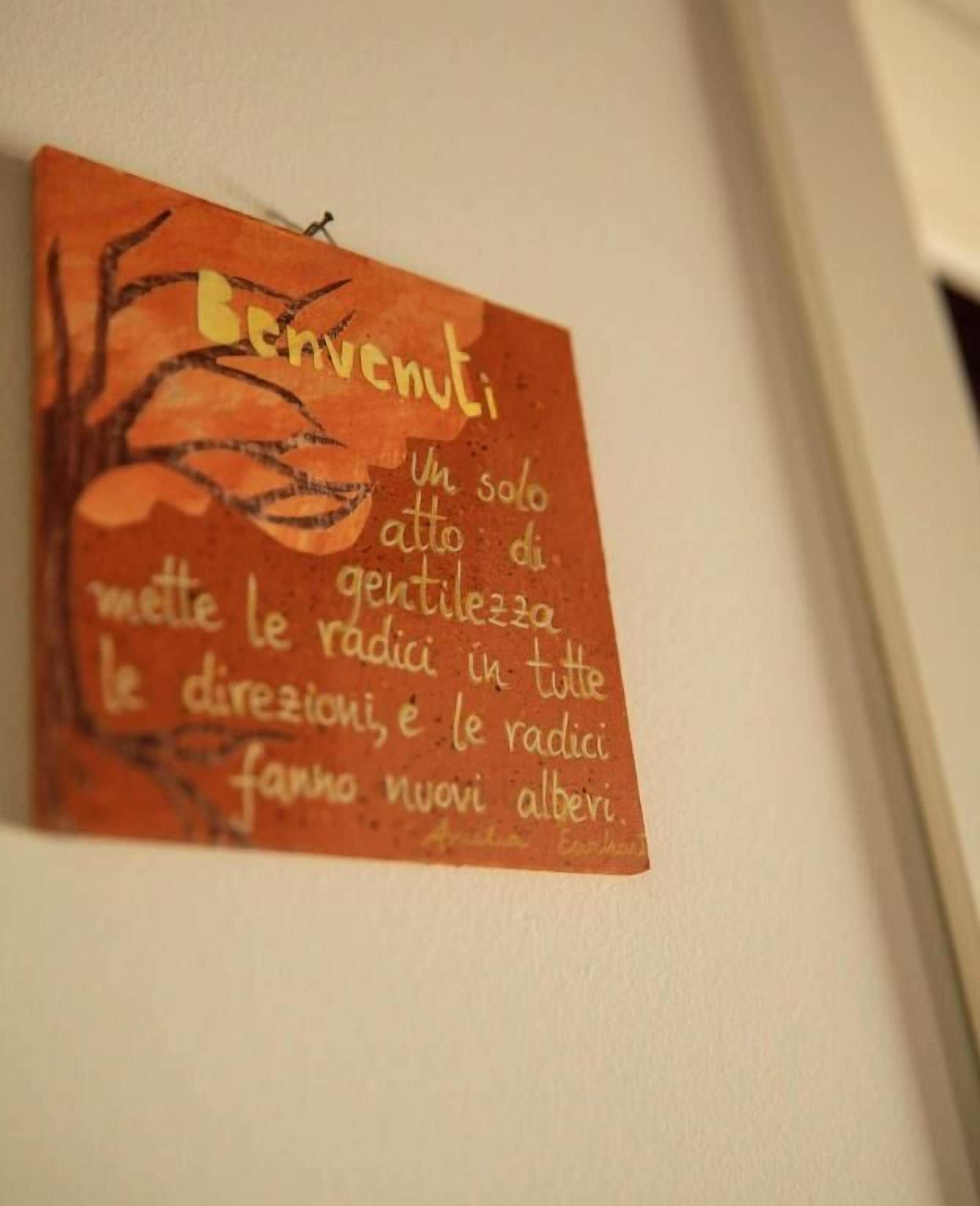 Pared amb una obra d'art que mostra text i una branca d'arbre.