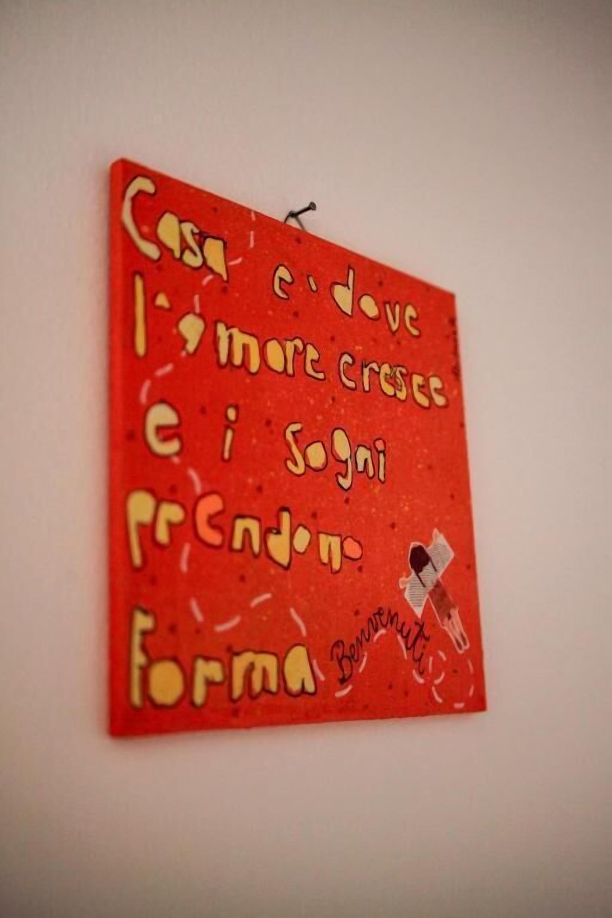 A red wall with a handwritten message in yellow and white.