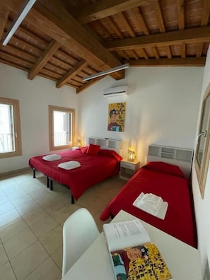 Een kamer met twee bedden, een bureau en een raam.