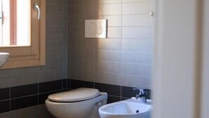 A bathroom with a toilet, bidet, and a sink. - Guesthouse Villa Fabris (Thiene)