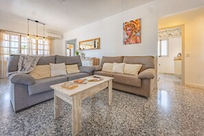 Ein Wohnzimmer mit zwei Sofas, einem Couchtisch und einem Gemälde an der Wand.