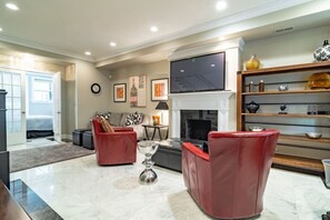 Comfortable living room w/ red chairs, fireplace & built-in shelves for a cozy hangout - Luxury 4BR 4-Story Chicago Villa |Prime Gold Coast (Chicago)
