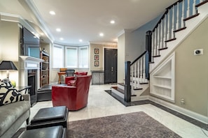 Stylish lower-level lounge w/ red chairs, TV & open layout for relaxing evenings - Luxury 4BR 4-Story Chicago Villa |Prime Gold Coast (Chicago)