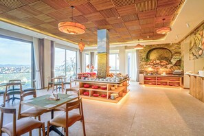 Un vaste espace dédié à la salle à manger, avec de hauts plafonds, de grandes fenêtres et un buffet central.
