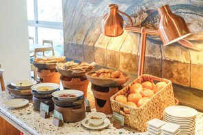 Buffet amb diversos aliments, com ara bols de sopa, plats de pa i una cistella de pastissos.