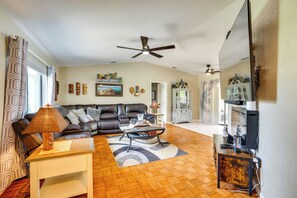 A living room with a sofa, coffee table, lamp, and a ceiling fan. - Heated Pool & Resort-Style Perks! Punta Gorda Home (Punta Gorda)