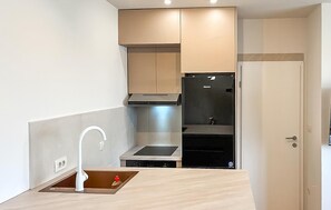 A modern kitchen with a built-in stove, a sink, and a refrigerator. - Nice apartment in Krvavac II with WiFi (Krvavac II)