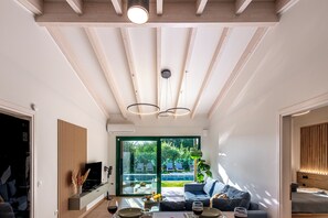 Ein modernes Wohnzimmer mit Fernseher, Sofa und Essbereich.
