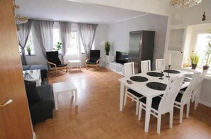 Ein modernes Wohnzimmer mit Essbereich, Fernseher und Kamin.