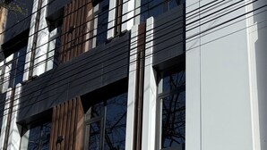 Un edificio moderno con un letrero que dice 'Hotel Tokyo' y un símbolo tradicional japonés.