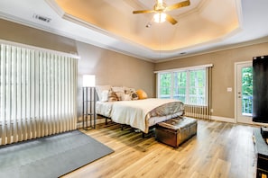 Ein Schlafzimmer mit Bett, einer Sitzbank, einem Deckenventilator und einem Fenster.