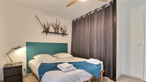 Une chambre à coucher comprenant un lit, une table de chevet, une lampe et une étagère murale décorée de branches.