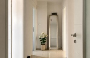 A hallway with a potted plant, a mirror, and a door with a modern handle. - Nice apartment in Sukosan with WiFi (Sukosan)