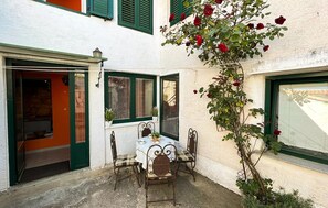 An outdoor patio with a table and chairs, a potted plant, and a climbing rose bush. - 2 bedroom gorgeous home in Grizane-Belgrad (Grizane-Belgrad)