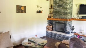 Ein Wohnzimmer mit Kamin, einem Glastisch und einer Couch.