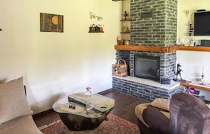 Ein Wohnzimmer mit Kamin, einem Glastisch und einer Couch.