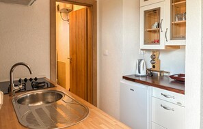 Eine kleine Küche mit Spüle, Herd und Kühlschrank.