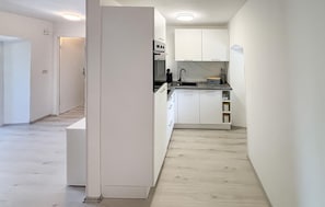 A modern kitchen with white cabinetry, a built-in oven, and a sink. - Stunning home in Dobrinj (Dobrinj)