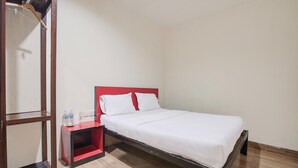 A single bed with a red headboard, a small bedside table with a red shelf, and a mirror on the wall. - Stylish DBL Suite Escape W/ Free Wifi and Parking (Batam)