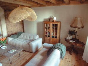 Ein gemütliches Wohnzimmer mit einer Couch, einem Holzschrank und einer Hängelampe.