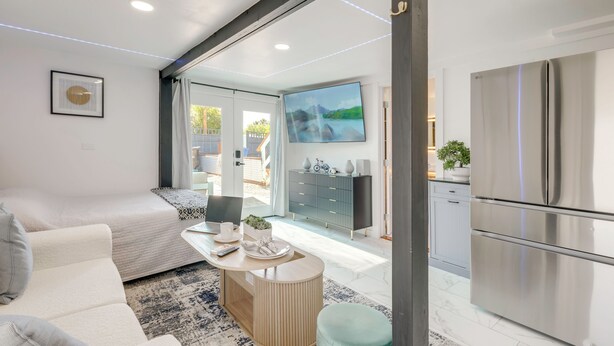 Uma sala de estar moderna com um sofá, uma mesa de centro e uma televisão.