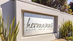 A sign for 'Hermanus Cliff Path Lodge' with a modern design and a clear view of the surrounding landscape. - Hermanus Cliff Path Lodge (Hermanus)