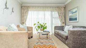 Habitación de lujo doble, patio | Zona de estar | Una televisión